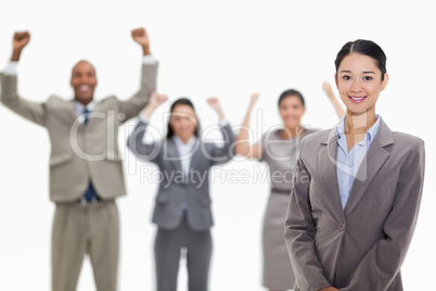 Businesswoman smiling with enthusiastic co-workers