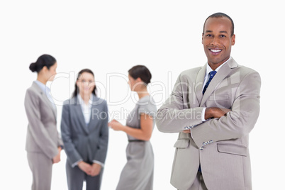 Businessman smiling with three co-workers talking in the backgro
