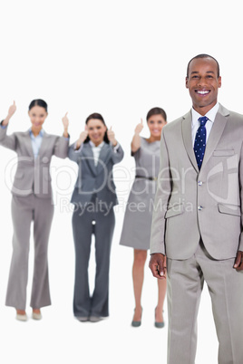 Happy businessman with approving co-workers in background
