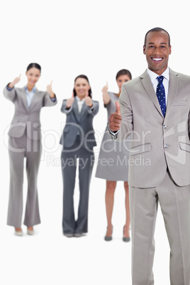 Business team smiling with thumbs up