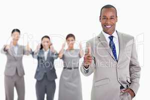 Happy businessman with a hand in his pocket approving with co-wo