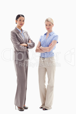 Two serious women crossing their arms