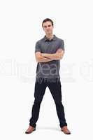 Standing man crossing his arms and his legs apart