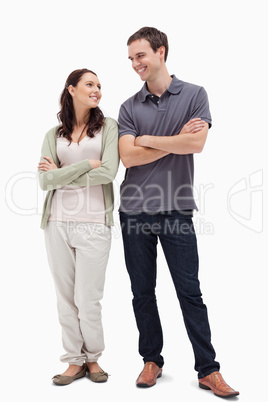 Couple with a complicit smile while crossing their arms