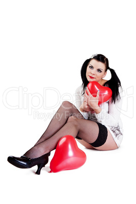 Frau mit Luftballon sitzt auf dem Boden