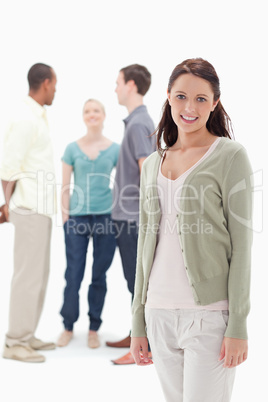 Woman smiling with her friends chatting behind