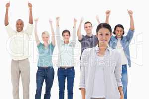 Close-up of a girl with people raising their arms with their thu