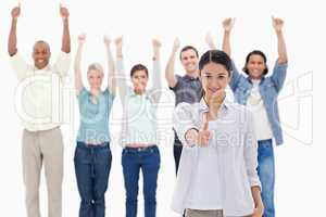 Close-up of a girl with people raising their arms and with their
