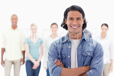 Close-up of a man crossing his arms with people behind