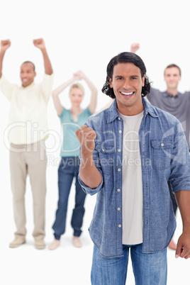 Big close-up of a man clenching his hand with people raising the