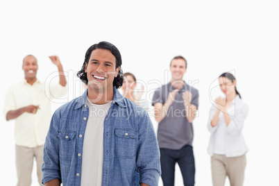 Close-up of a man laughing with people applauding