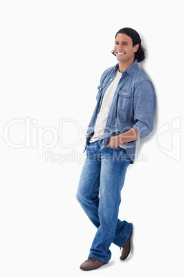 Man laughing while leaning against a wall
