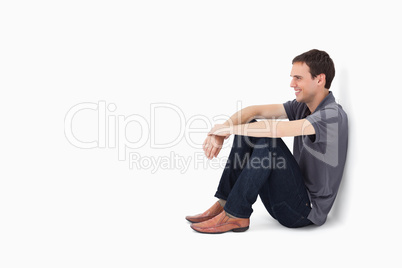 Smiling man sitting against a wall