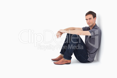 Man sitting against a wall