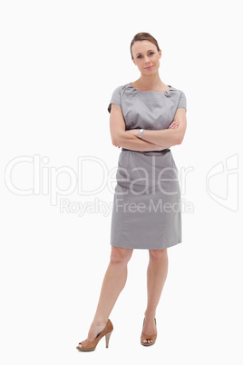 Woman in dress standing with her arms folded