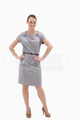 Smiling woman posing in a dress with her hands on her hips