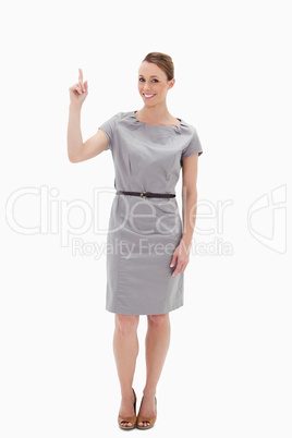 Woman posing in a dress showing something above with her hand