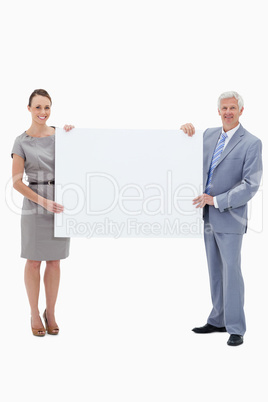 White hair businessman smiling and holding a big white sign with