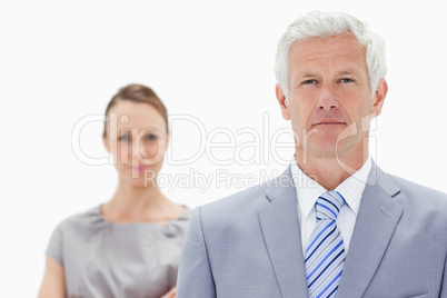 Close-up of a serious white hair businessman with a woman behind