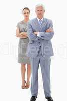 White hair businessman with a woman in background crossing their