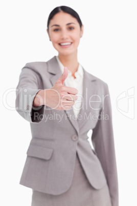 Thumb up given by smiling businesswoman