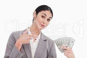 Saleswoman pointing at bank notes in her hand