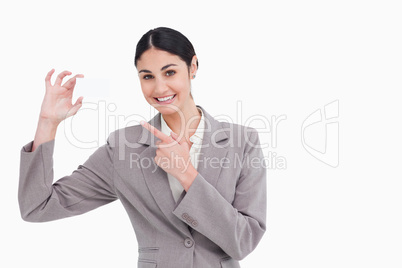 Smiling saleswoman pointing at her business card