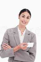 Saleswoman with arms folded and business card