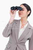 Businesswoman looking through spy glasses
