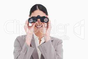 Smiling businesswoman looking through spy glasses