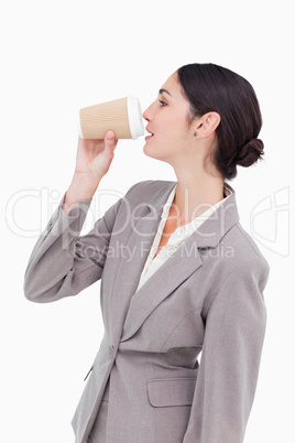 Side view of businesswoman taking a sip out of a paper cup