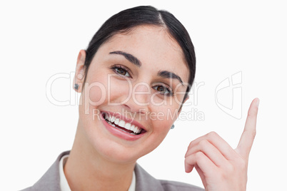 Close up of smiling businesswoman pointing up