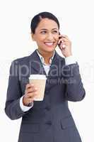 Close up of saleswoman with paper cup on her cellphone