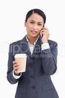 Close up of serious saleswoman with paper cup and cellphone
