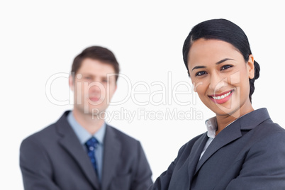 Close up of smiling saleswoman with co-worker behind her