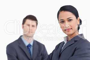 Close up of confident saleswoman with co-worker behind her