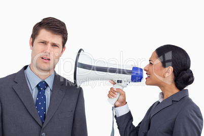 Close up of saleswoman with megaphone yelling at colleague