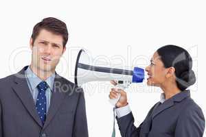 Close up of saleswoman with megaphone yelling at colleague