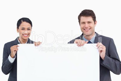 Close up of smiling salesteam holding blank sign