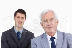 Close up of mature businessman with colleague behind him