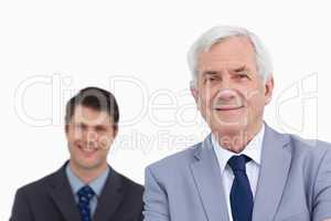 Close up of mature businessman with employee behind him