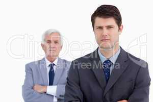 Close up of serious businessman with his mentor behind him