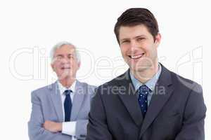 Close up of smiling businessman with his boss behind him
