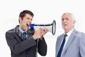 Close up of businessman with megaphone yelling at his boss