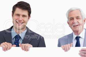 Close up of smiling businessmen holding blank sign