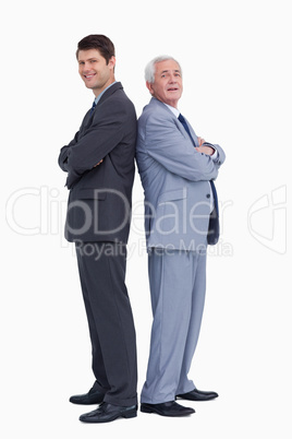 Smiling businessmen standing back to back