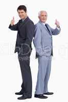 Businessmen standing back to back giving thumbs up