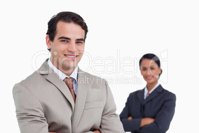 Smiling salesman with co-worker behind him