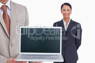 Laptop being presented by salesman with colleague behind him