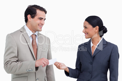 Smiling sales partner exchanging business cards